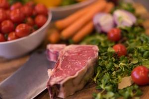 suculenta fatia de bife cru na mesa de madeira foto