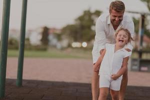 um homem idoso em roupas casuais com sua filha passa tempo juntos no parque de férias. tempo para a família. foco seletivo foto