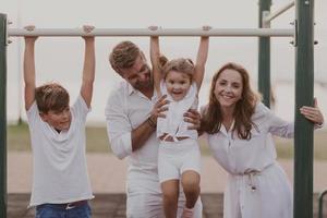 casal sênior em roupas casuais com seus filhos passando um tempo no parque de férias juntos. tempo para a família . foco seletivo foto