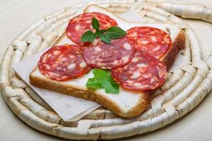 sanduíche de salame na madeira foto