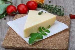 queijo parmesão na tábua de madeira e fundo de madeira foto