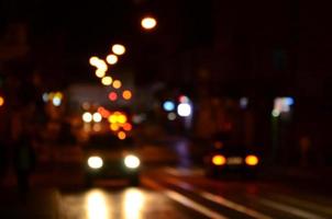 cena noturna turva de tráfego na estrada. imagem desfocada de carros viajando com faróis luminosos. arte bokeh foto