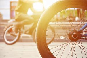 uma roda de bicicleta bmx no contexto de uma rua turva com ciclistas. conceito de esportes radicais foto