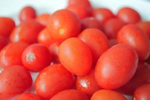 tomate pequeno de cor vermelha na mesa foto