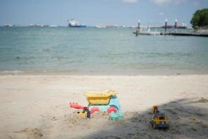brinquedos de plástico multicoloridos em uma grande praia de areia do mar foto