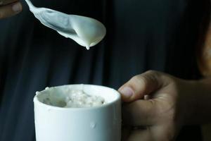 colocando iogurte em granola musli em uma tigela, foto