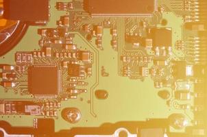 uma imagem macro tonificada de uma placa de computador com muitos pequenos elementos tecnológicos. profundidade de campo extremamente rasa. fundo tecnológico abstrato foto