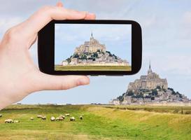 turista tirando foto da abadia de mont saint-michel