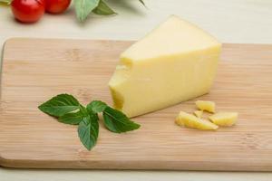 queijo parmesão na tábua de madeira e fundo de madeira foto