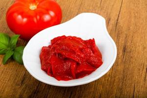 pasta de tomate em uma tigela sobre fundo de madeira foto