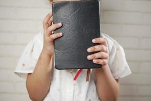 menina criança segurando muitos blocos de notas coloridos situados na cadeira foto