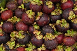 mangostão saudável e fresco, arrumado para venda nos mercados tradicionais. fundo de frutas frescas foto