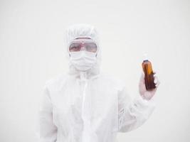 retrato de médico ou cientista em uniforme de conjunto de ppe segurando garrafa de plástico com produto para cuidados com a pele. fundo branco isolado conceito covid-19 foto