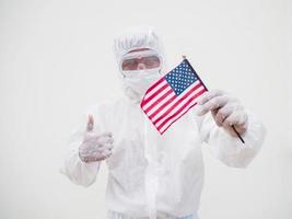 retrato de médico ou cientista em uniforme de conjunto de ppe segurando a bandeira nacional dos estados unidos da américa. fundo branco isolado conceito covid-19 foto