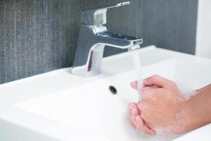 higiene. mãos de limpeza. lavar as mãos com sabão sob a torneira com água paga. prevenir esterilizar a doença de bactérias germinativas. conceito de cuidados de saúde. foto