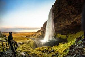 Islândia - 5 de novembro de 2017 - turistas caminhando para a caverna atrás de seljalandsfoss foto
