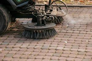 o serviço municipal realiza trabalhos sazonais no parque. o varredor recolhe muitos detritos. as escovas varrem o asfalto foto