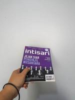 west java, agosto de 2022. uma mão está segurando uma edição de dezembro de 2021 da revista intisari com o tema traços do evangelista do arquipélago foto