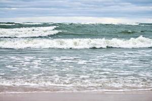 mar azul, ondas, praia e céu nublado. paisagem do mar báltico foto