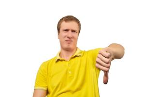 homem irritado infeliz na camiseta amarela mostrando os polegares para baixo gesto isolado no fundo branco foto
