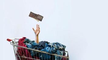 conceito de viciado em compras. mão feminina sai do carrinho de compras foto