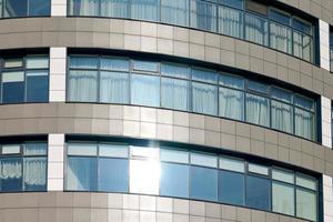 vista de perto para janelas de arranha-céus de escritório, janelas de prédios de negócios altos com brilho da luz solar foto