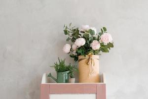 rosas artificiais em um vaso, em um regador, como decoração para um quarto infantil foto
