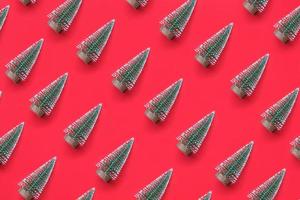 flatlay mínimo de padrão de árvore de natal verde no conceito de celebração de feriado de ano novo de fundo vermelho foto