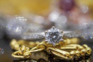 anéis de diamante de joias de ouro de luxo com reflexo no fundo preto foto