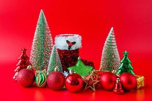 árvore de natal e enfeites no conceito de celebração de feriado de ano novo de fundo vermelho foto