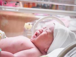 bebê recém-nascido dentro da incubadora na sala de parto pós-hospital foto