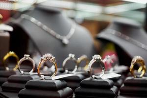 anéis e colares de diamante de joias são exibidos em vitrine de loja de varejo de luxo foto