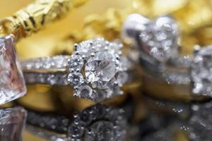 anéis de diamante de joias de ouro de luxo com reflexo no fundo preto foto