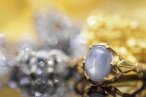 anéis de safira azul de joias de ouro vintage com reflexo no fundo preto foto
