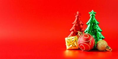 árvore de natal e enfeites no conceito de celebração de feriado de ano novo de fundo vermelho foto