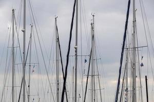 mastros de navio em um porto com nuvens foto