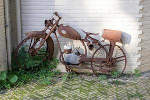 velha bicicleta enferrujada na frente de uma casa foto