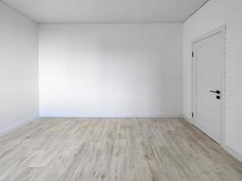 interior da sala vazia - parede branca com uma porta e piso foto