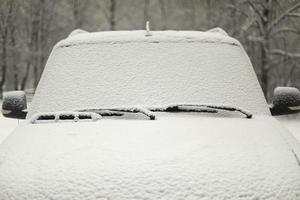 neve de carro. transporte no inverno no estacionamento. camada de neve no carro. foto