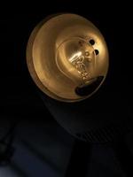 candeeiro de mesa no escuro. lâmpada incandescente no interior. foto