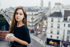 mulher sonhadora com caneca na varanda foto