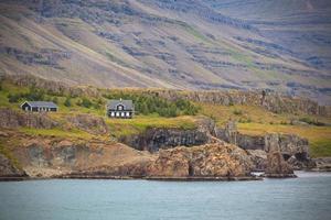 paisagem islandesa com casas em montanhas nevoentas foto