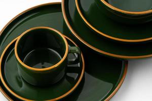 um conjunto de talheres de cerâmica verde escuro com contornos laranja foto