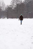mulher andando pelo campo coberto de neve foto