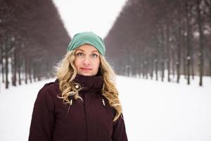mulher vestindo roupas quentes de inverno no beco coberto de neve foto