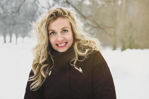 mulher desfrutando de um passeio de inverno pelo parque coberto de neve foto