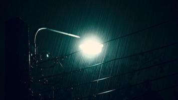 chovendo noite e luz. gotas de chuva caindo à noite em bangkok tailândia na estação chuvosa de agosto. foto