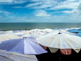 grande guarda-chuva lotado ao longo da praia de cha-am foto