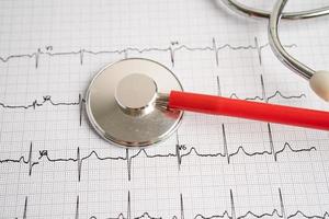 estetoscópio no eletrocardiograma ecg, onda cardíaca, ataque cardíaco, relatório do eletrocardiograma. foto