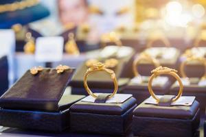 brincos e colares de anéis de ouro de joias são exibidos em vitrine de loja de varejo de luxo foto
